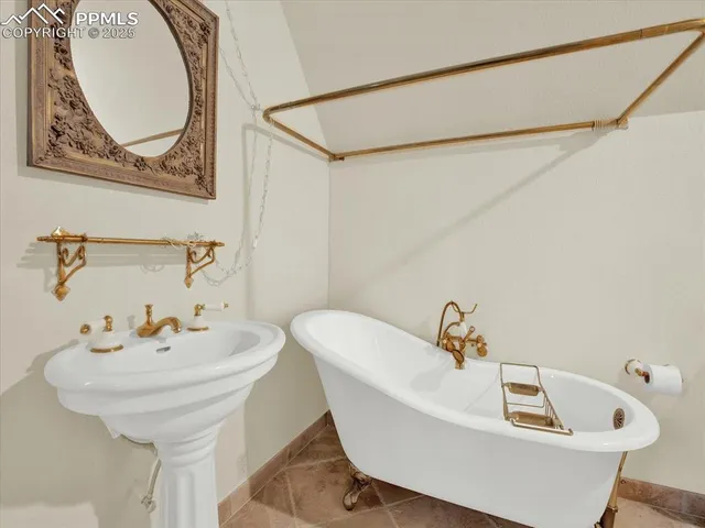 a white bath tub sitting next to a white sink and a mirror