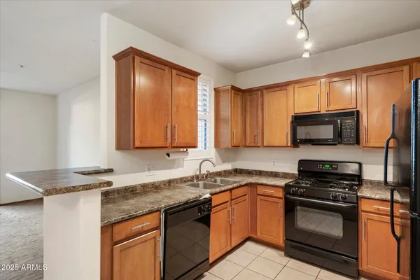 a kitchen with stainless steel appliances granite countertop a sink stove and microwave
