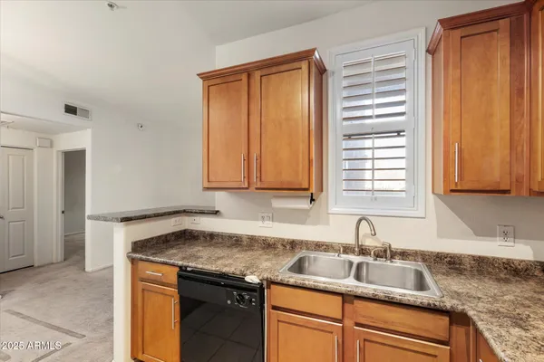 a kitchen with granite countertop cabinets sink and window