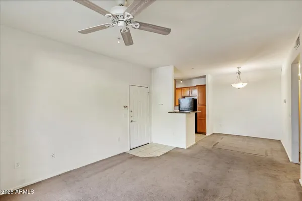 an empty room with closet and a ceiling fan