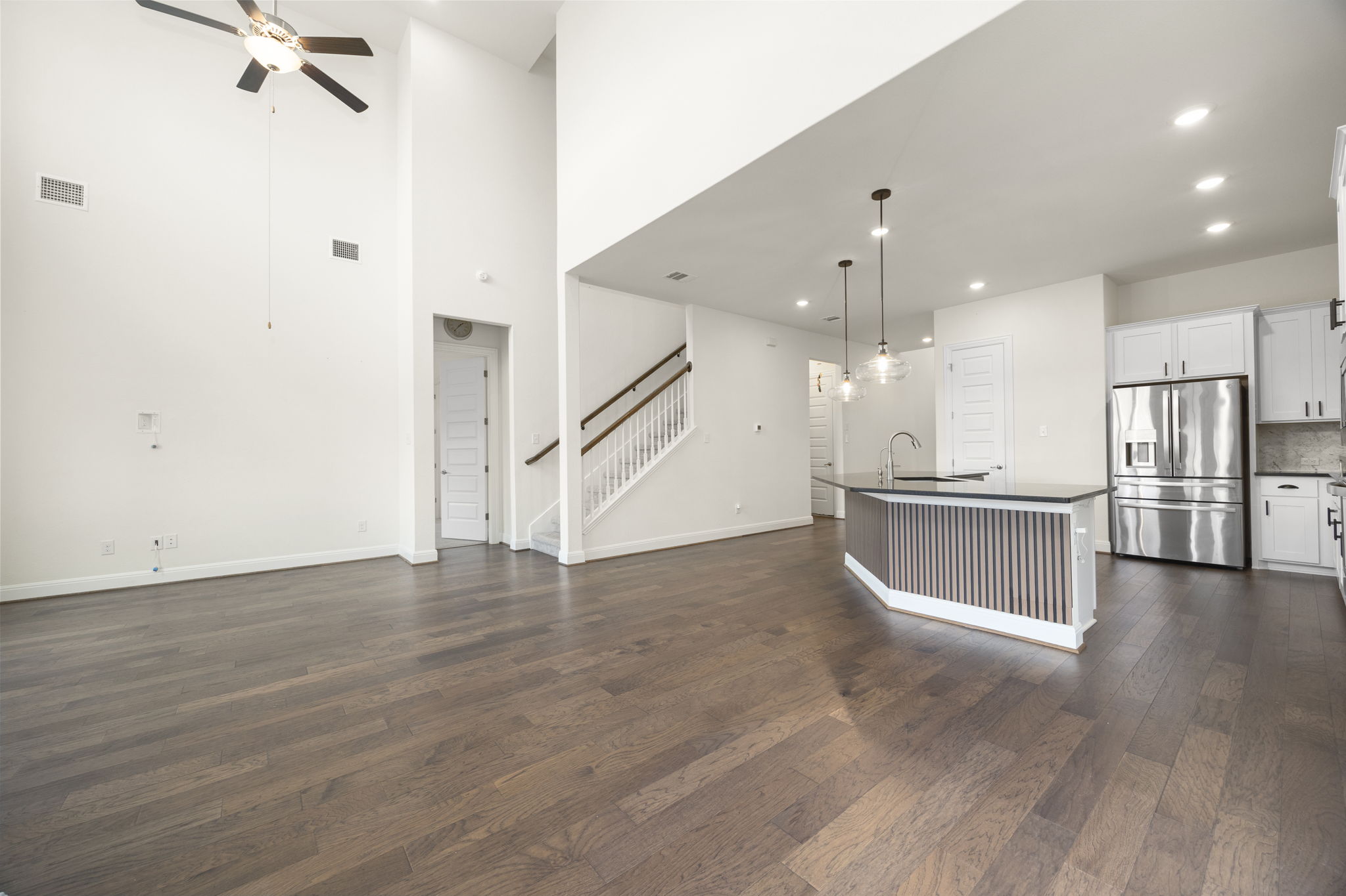1098 Cherrystone Loop Buda, TX 78610 - Photo 12 of 37 a view of an empty room with wooden floor and a ceiling fan