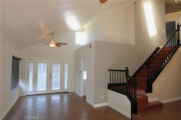 a view of staircase with railing and a chandelier