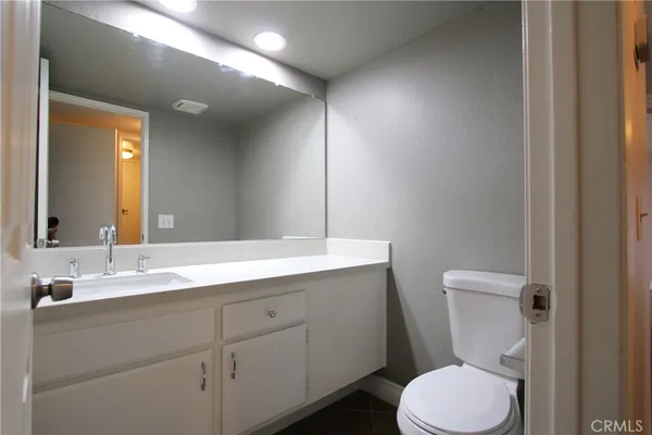 a bathroom with a toilet sink vanity and mirror