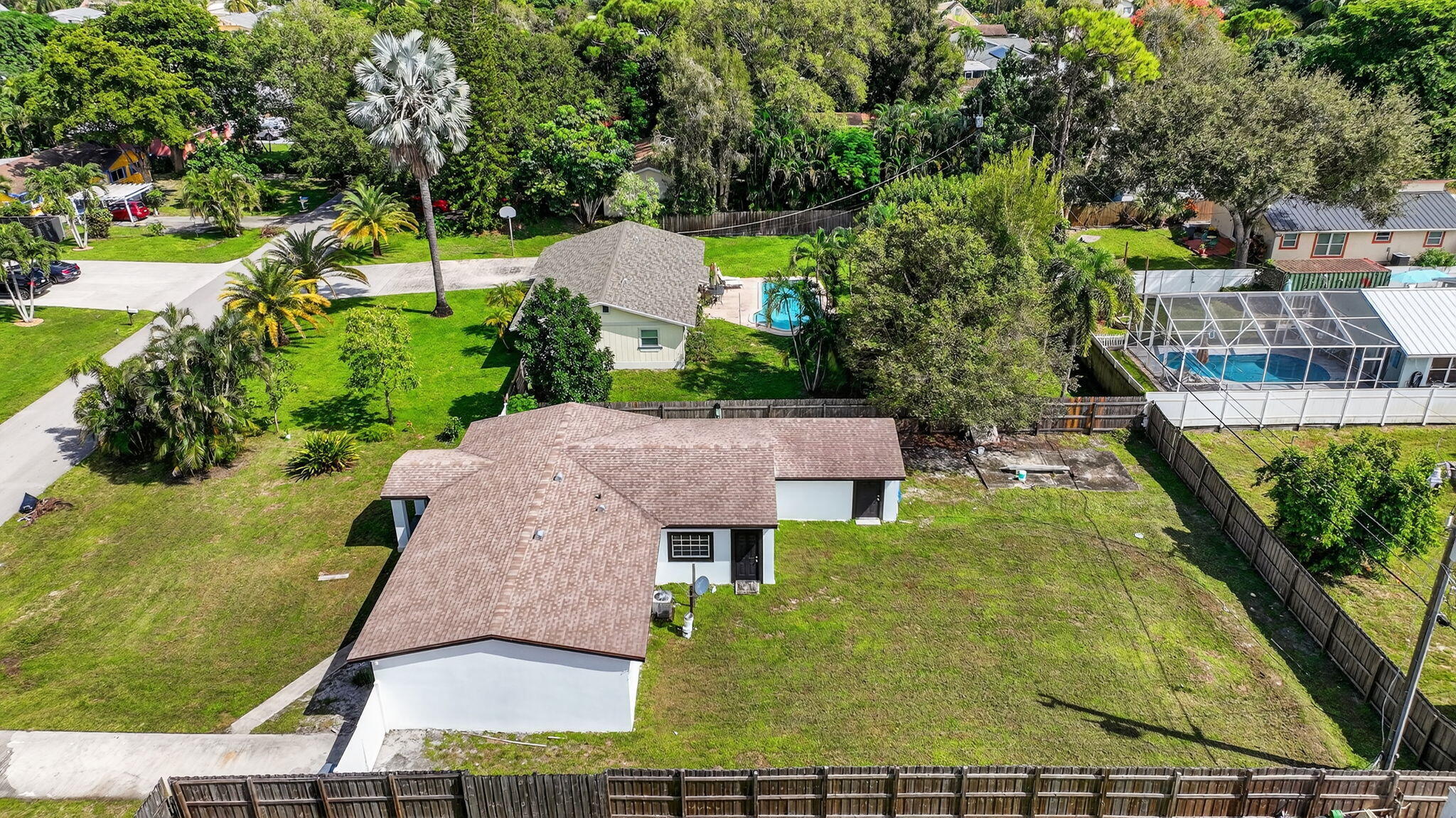 5196 Palm Ridge Boulevard Delray Beach, FL 33484 - Photo 23 of 24 an aerial view of a house with swimming pool and large trees
