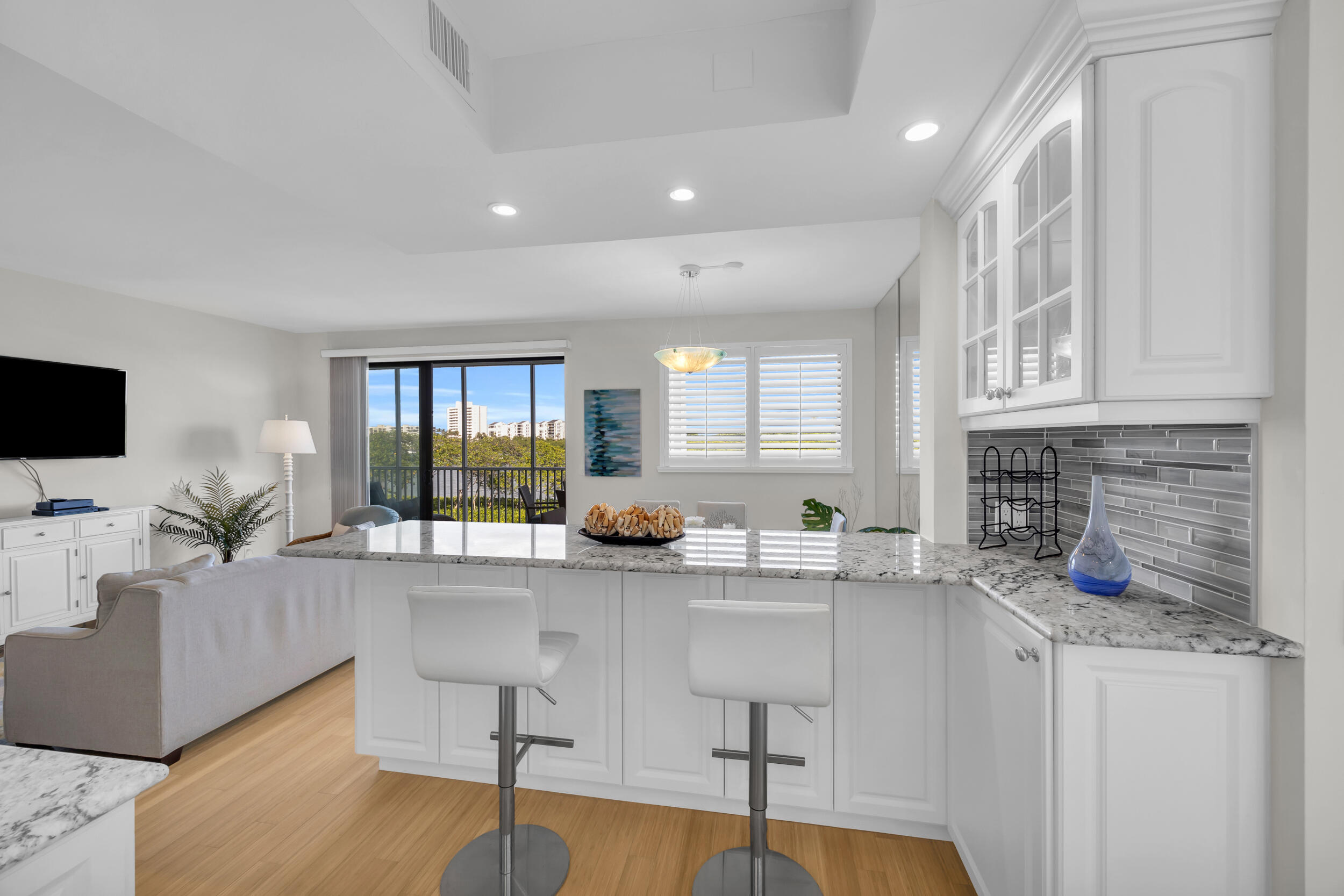 200 Waterway Road, Unit 206 Tequesta, FL 33469 - Photo 16 of 49 a kitchen with granite countertop a sink and a stove top oven with wooden floor