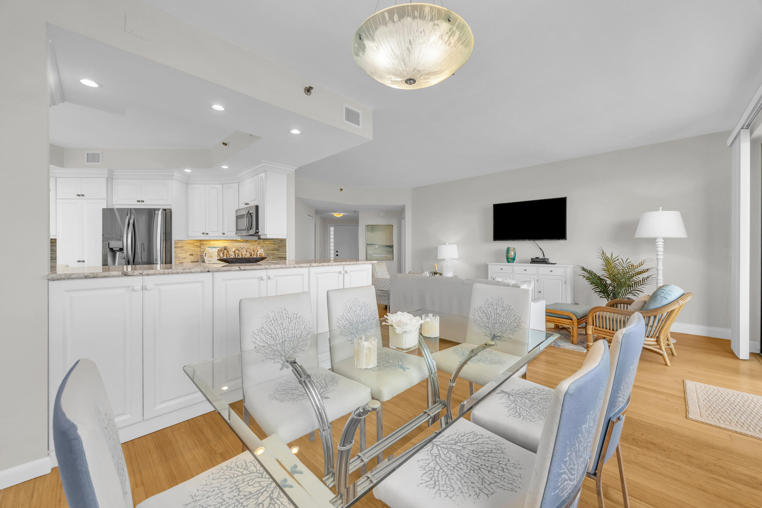 200 Waterway Road, Unit 206 Tequesta, FL 33469 - Photo 7 of 49 a living room with furniture a flat screen tv and kitchen view