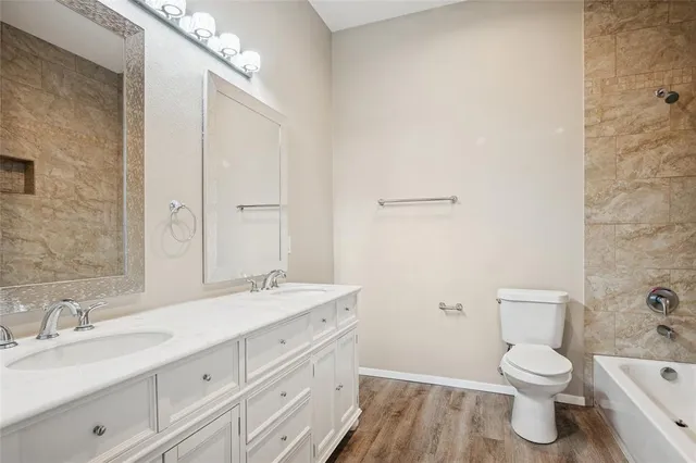 a bathroom with a granite countertop toilet sink and mirror