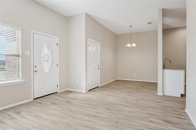 an empty room with wooden floor and mirror