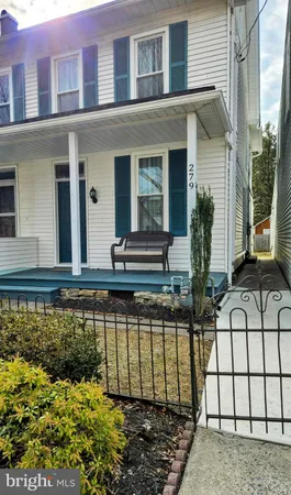 a view of a house with a small yard and potted plants