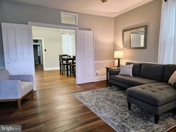 a living room with furniture and a wooden floor