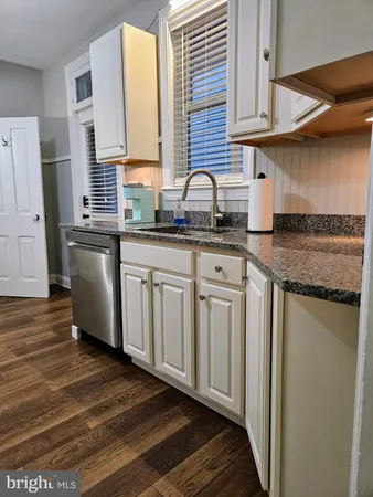 a kitchen with stainless steel appliances granite countertop a sink and a stove