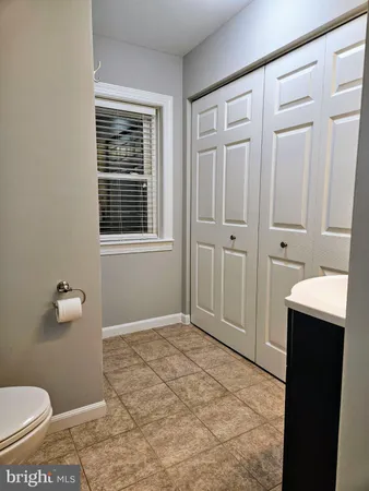 a bathroom with a granite countertop sink and a toilet