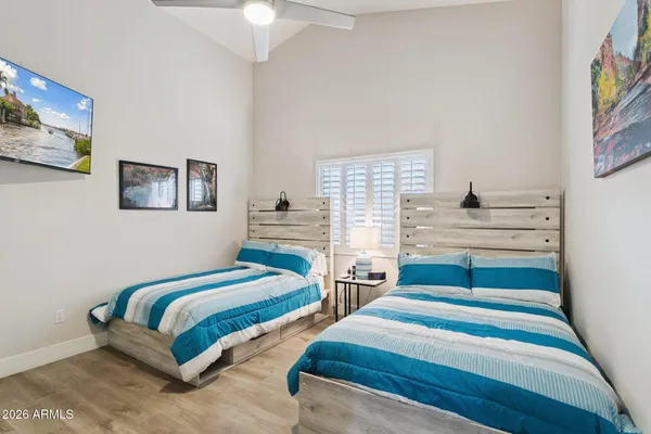 a bedroom with two beds and painting on the wall