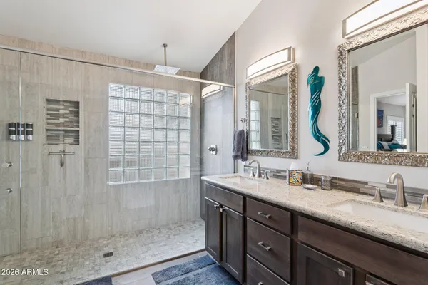 a bathroom with a double vanity sink mirror and shower