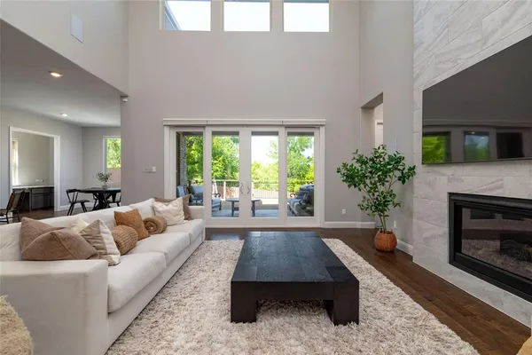a living room with furniture a large window and a fireplace