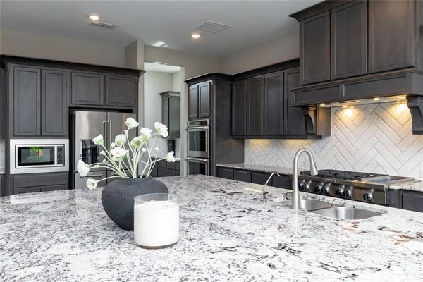 a kitchen with a refrigerator and a stove top oven