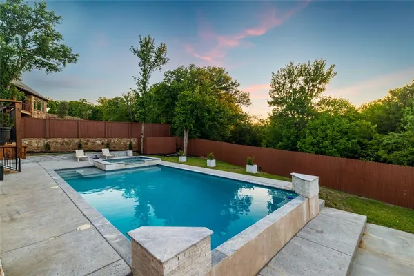 a view of a swimming pool with a lounge chair and a small yard