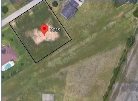 a sign that is on a brick wall with a painting on the wall