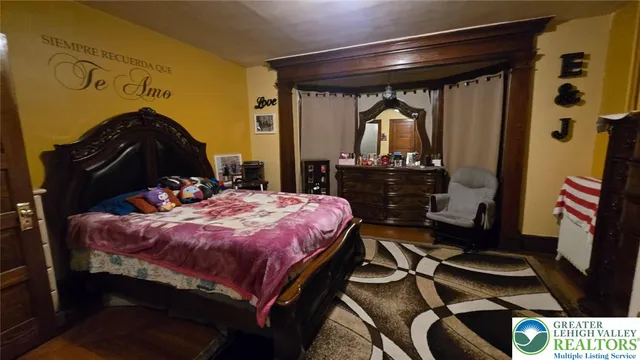 a bedroom with a bed and a flat tv screen on the dresser