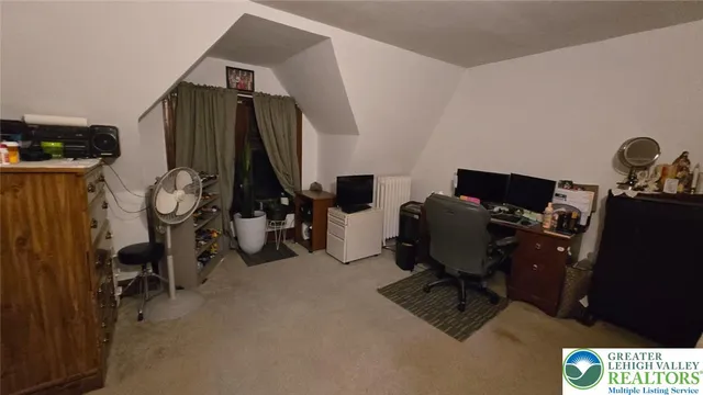 a bedroom with a bed and a flat tv screen on wall