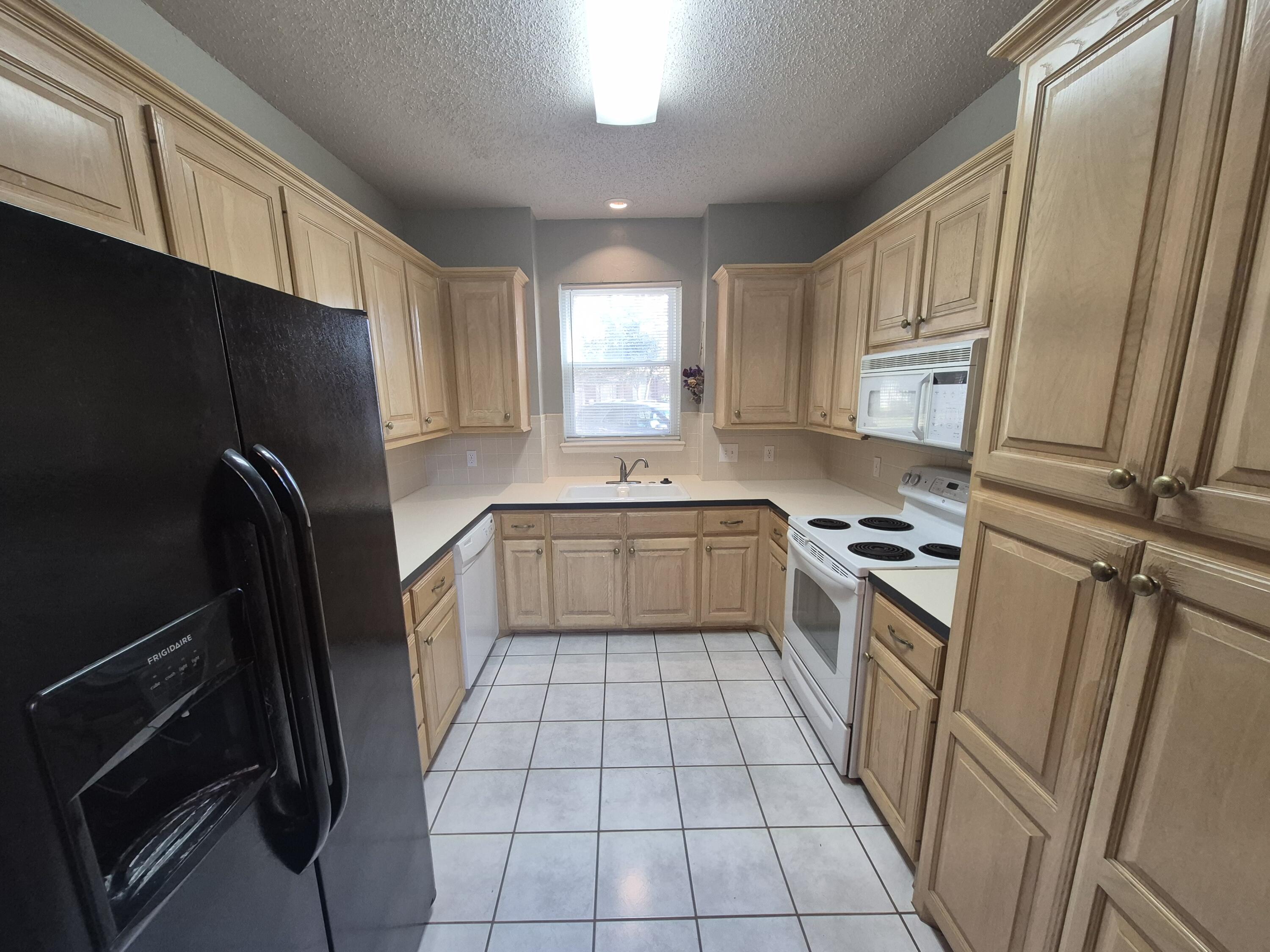 5117 79th Drive Lubbock, TX 79424 - Photo 11 of 35 a kitchen with a refrigerator sink and cabinets