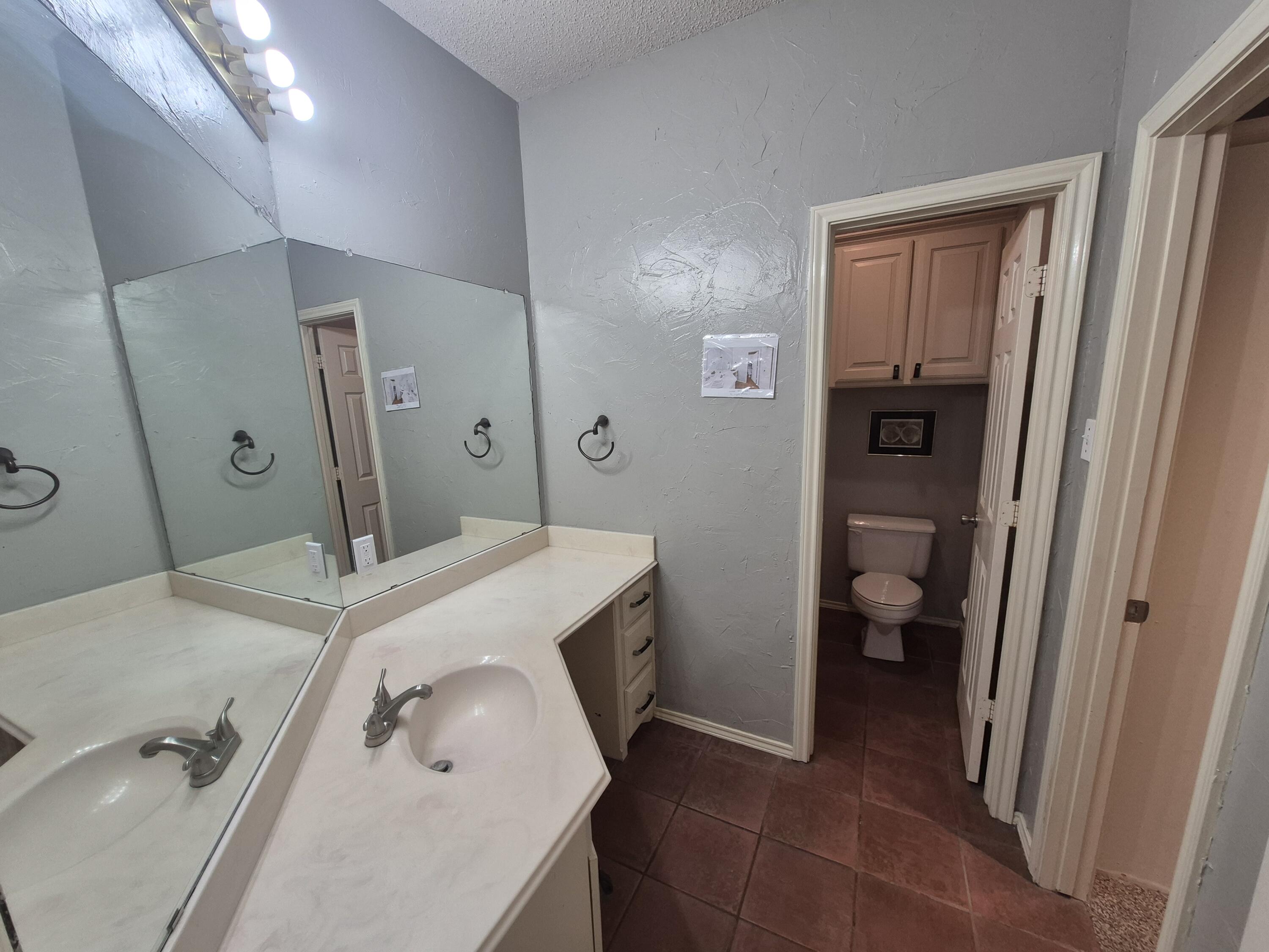 5117 79th Drive Lubbock, TX 79424 - Photo 17 of 35 a en suite bathroom with a sink a toilet and a shower