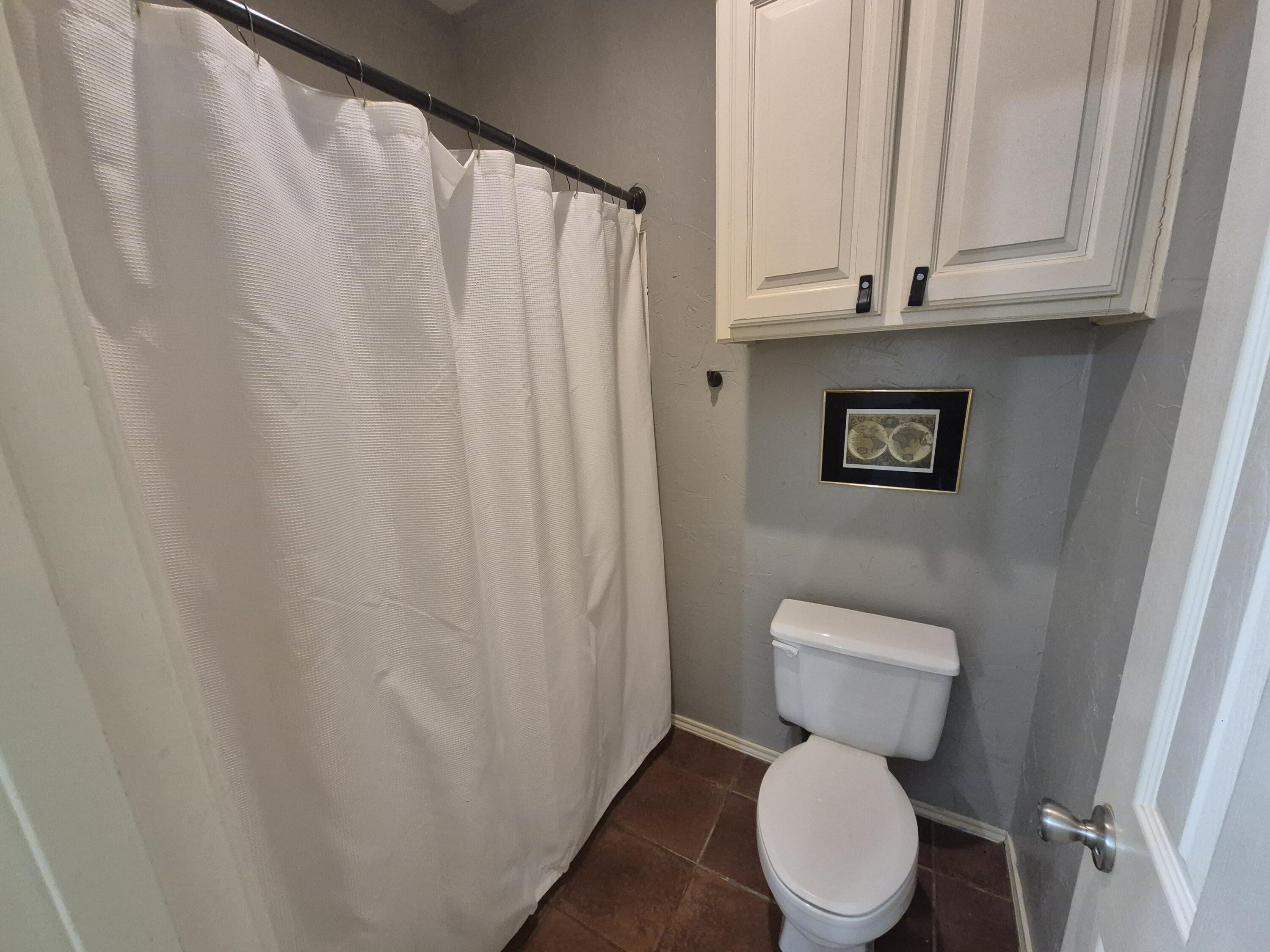 5117 79th Drive Lubbock, TX 79424 - Photo 18 of 35 a white toilet sitting next to a white cabinet