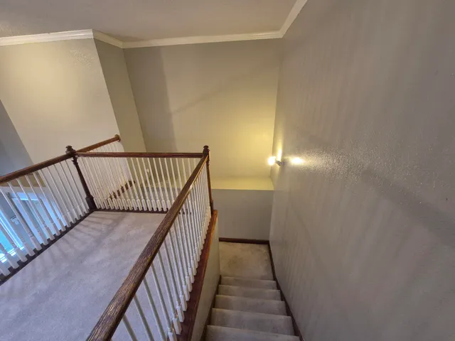 a view of a hallway with wooden floor and staircase
