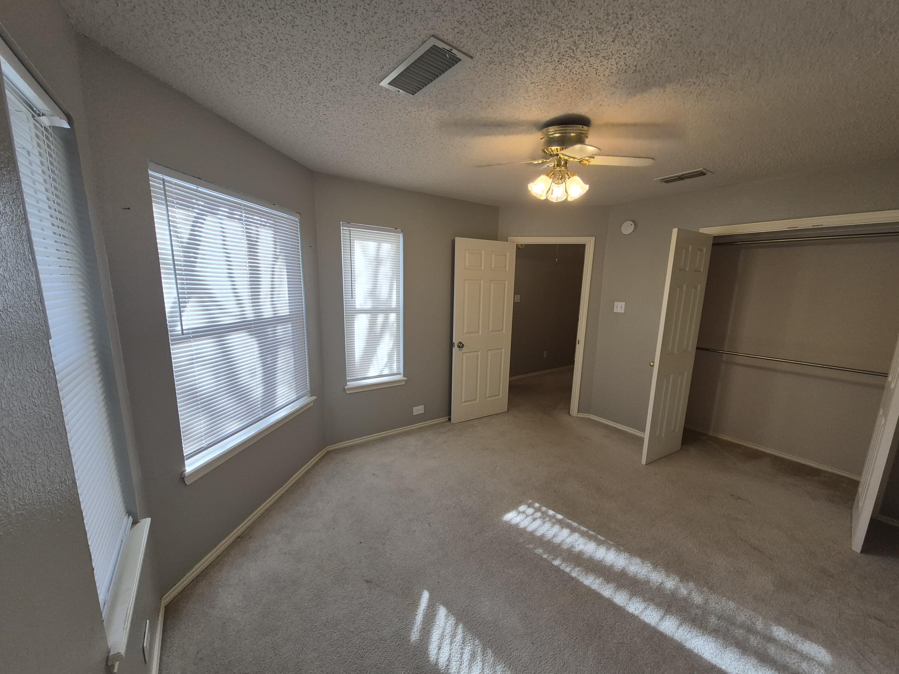 5117 79th Drive Lubbock, TX 79424 - Photo 25 of 35 an empty room with chandelier fan and windows