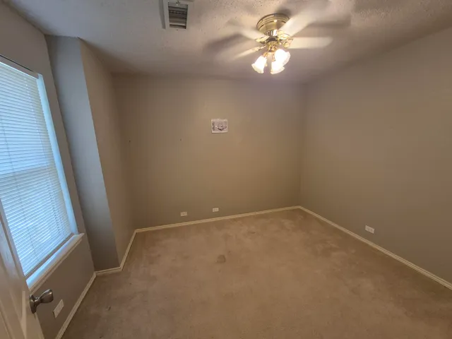 an empty room with closet and a ceiling fan