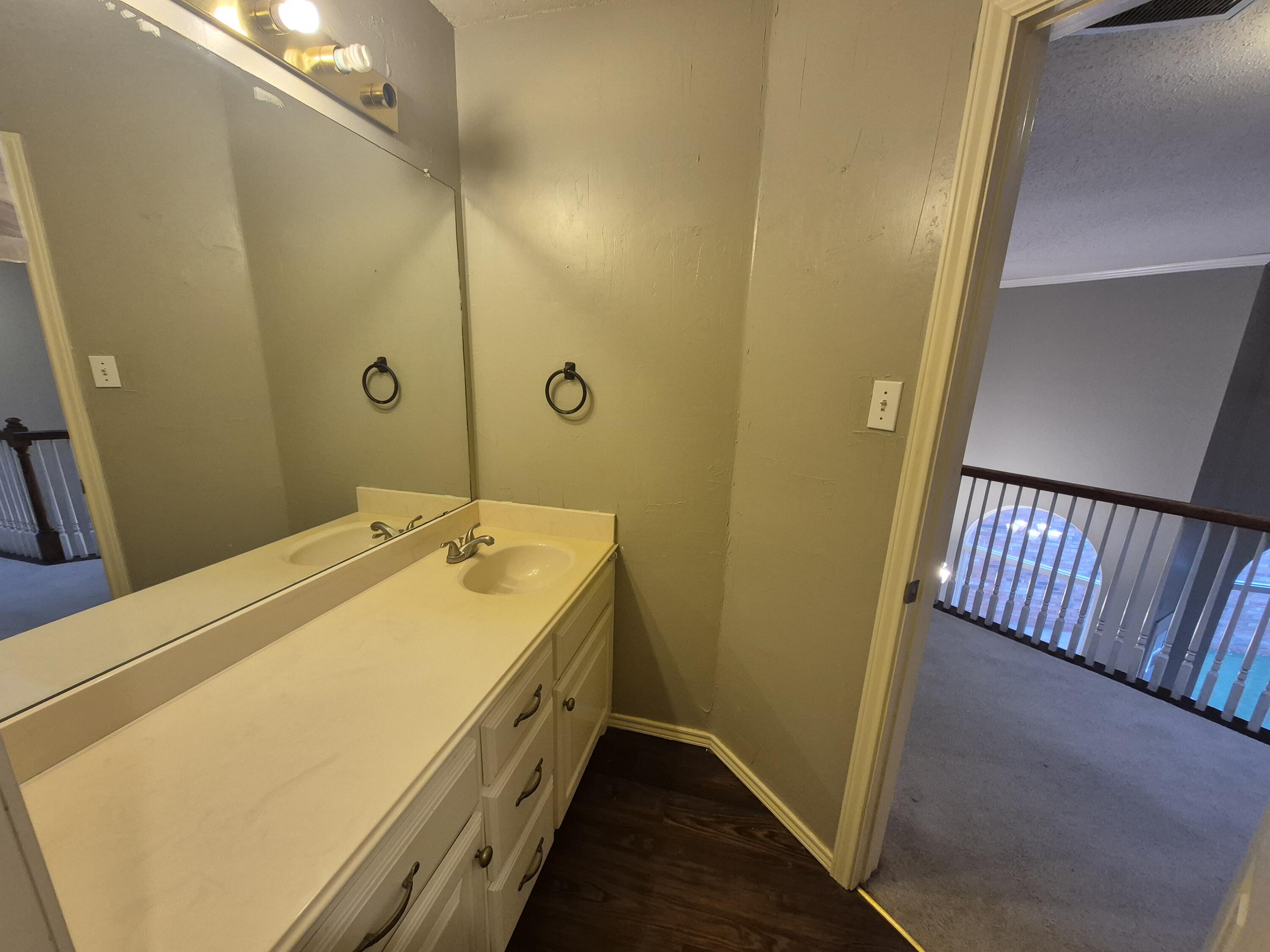 5117 79th Drive Lubbock, TX 79424 - Photo 30 of 35 a bathroom with a granite countertop sink and a mirror