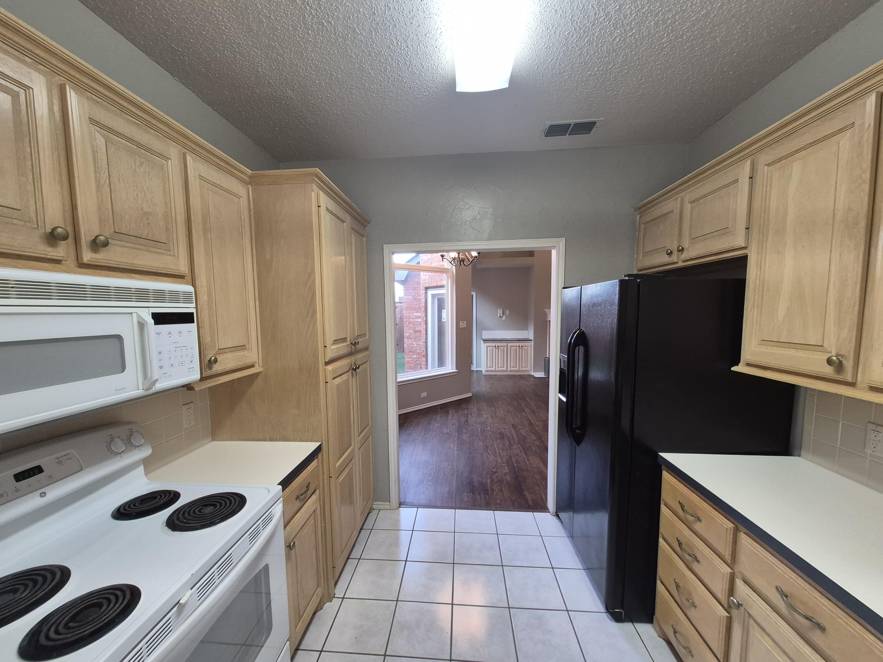 5117 79th Drive Lubbock, TX 79424 - Photo 10 of 35 a kitchen with a refrigerator and a sink