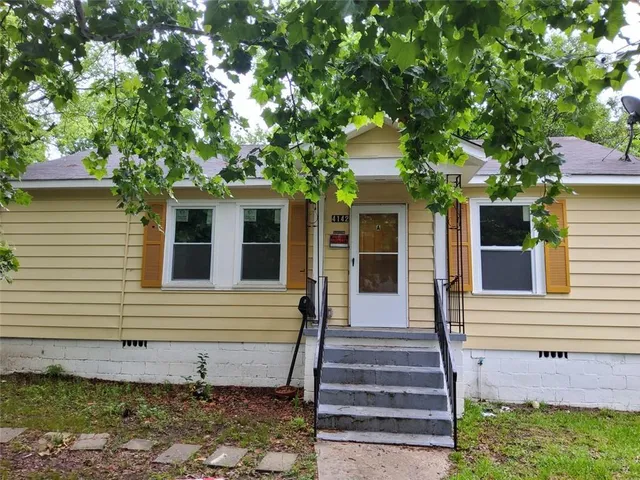 a view of a house with a tree front of house