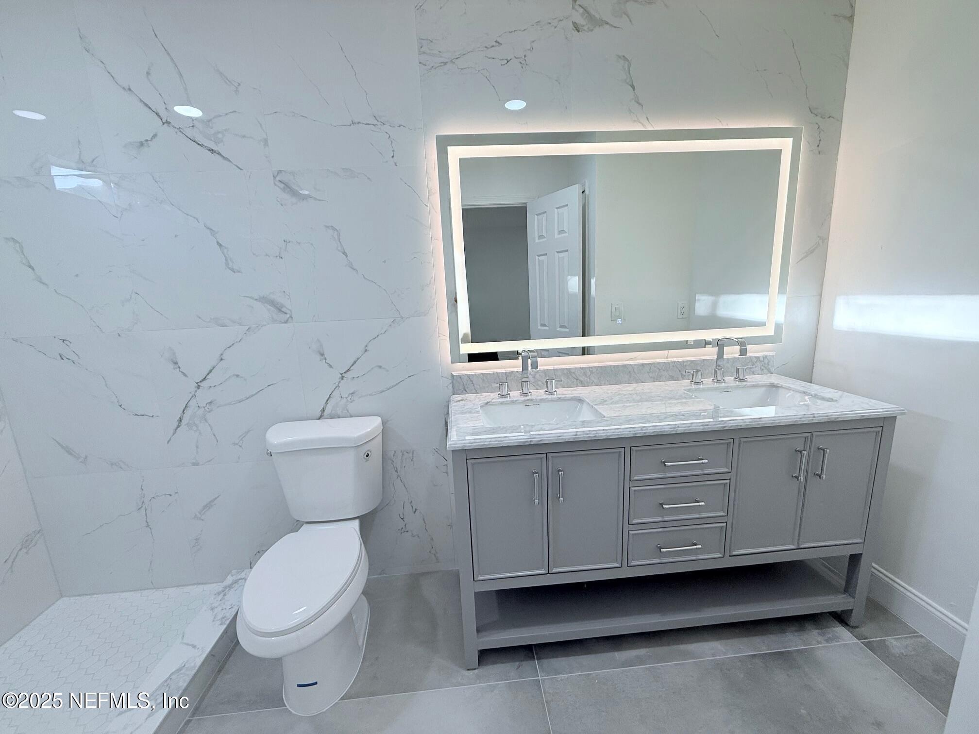 2160 Rothbury Drive Jacksonville, FL 32221 - Photo 16 of 38 a bathroom with a granite countertop sink mirror vanity and toilet