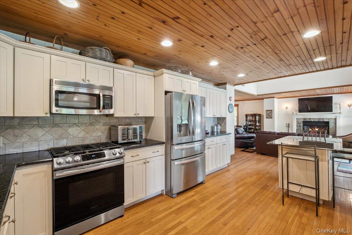 342 Lake Shore Road Putnam Valley, NY 10579 - Photo 46 of 46 Kitchen with appliances with stainless steel finishes, open floor plan, light wood-style flooring, backsplash, and recessed lighting