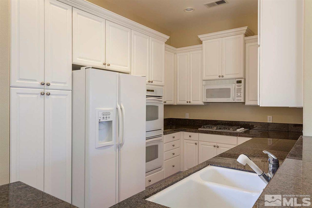 9900 Wilbur May, Unit 3805 Reno, NV 89521 - Photo 2 of 5 a kitchen with white cabinets and white appliances