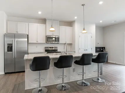 a kitchen with stainless steel appliances kitchen island a refrigerator a stove a sink and a granite counter tops