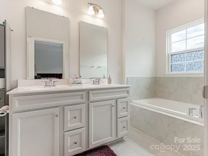 a bathroom with a bathtub a sink a vanity and a window