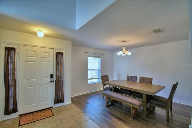 a living room with a table and a chandelier