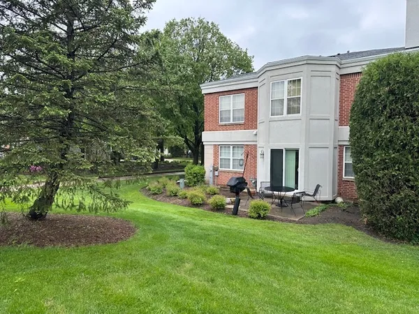 a front view of a house with a yard and trees