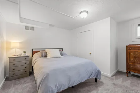 a small yard in front of a brick house with large trees