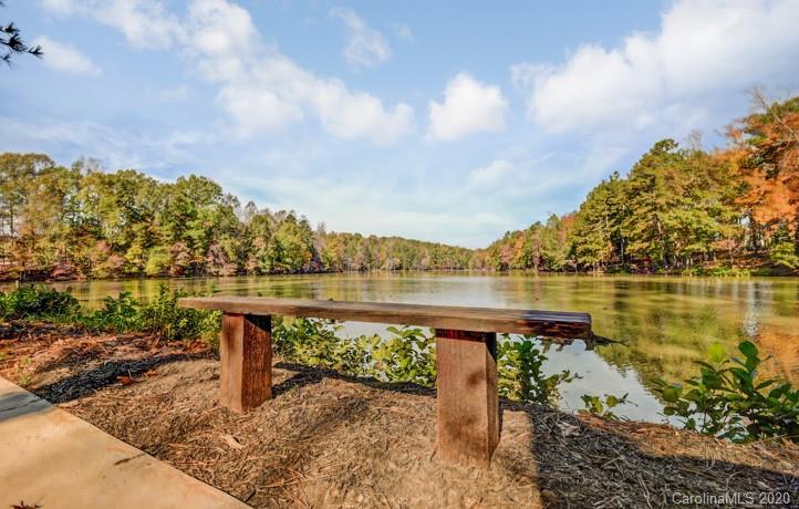 5116 Tranquility Boulevard, Unit 673 Lancaster, SC 29720 - Photo 5 of 9 a view of a lake with a table and chairs