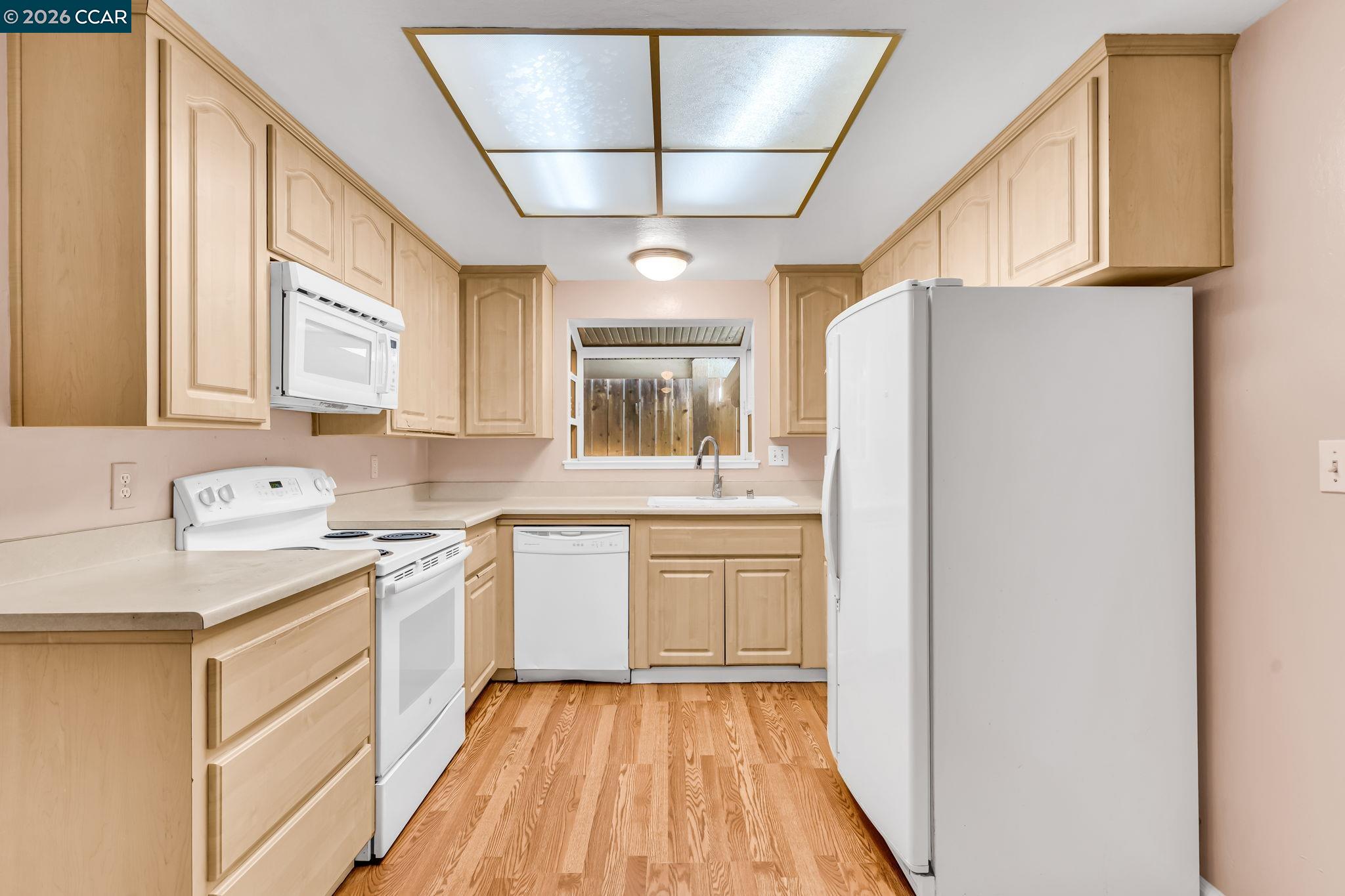 3321 Fraser Road Antioch, CA 94509 - Photo 17 of 46 a kitchen with a refrigerator a sink and dishwasher with wooden floor