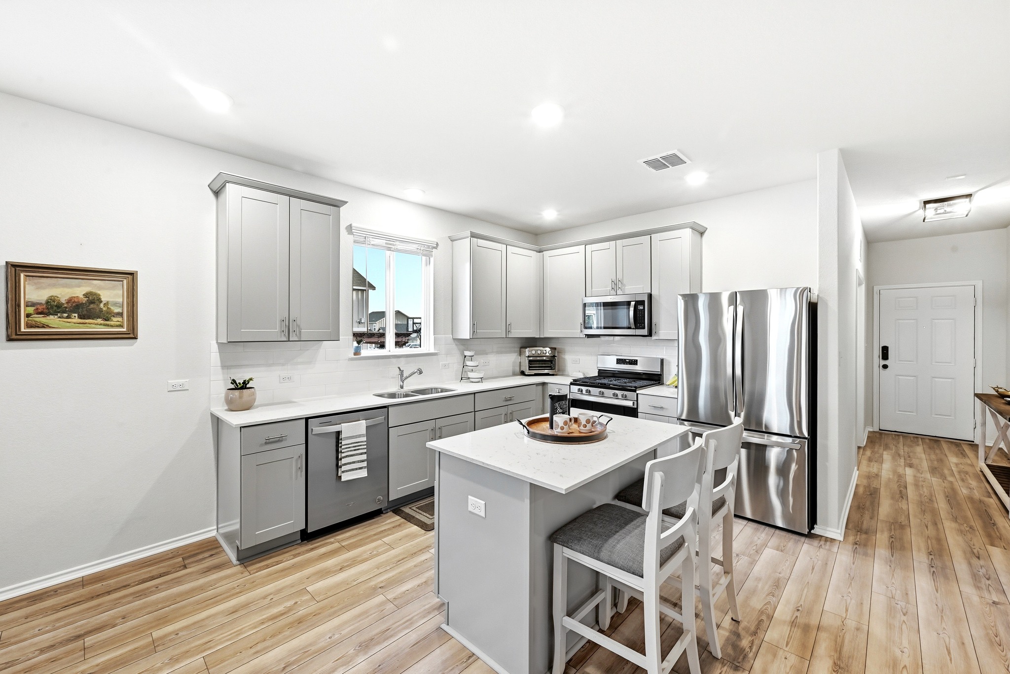 462 Tree Nut Loop Buda, TX 78610 - Photo 4 of 38 The kitchen is built around a large quartz island that serves as a central prep space and gathering spot