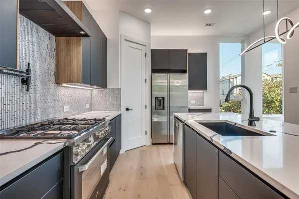 a kitchen with stainless steel appliances a sink stove and refrigerator