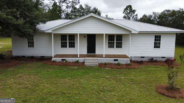 a backyard of a house with table and chairs