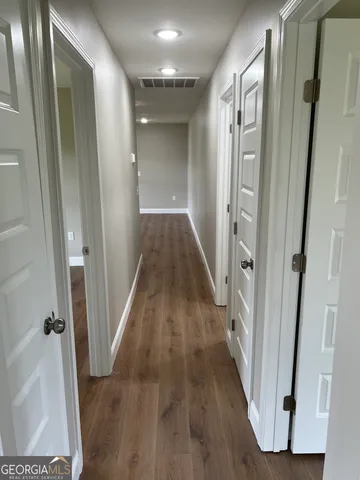a view of a hallway with wooden floor and staircase