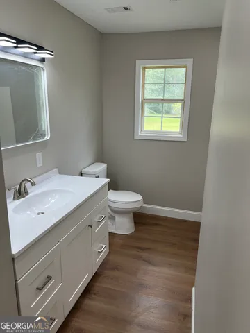 a bathroom with a toilet sink and mirror