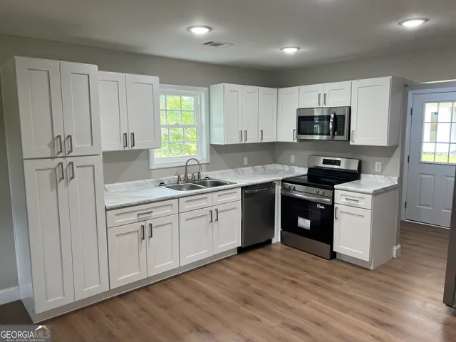 a kitchen with stainless steel appliances granite countertop a sink and cabinets