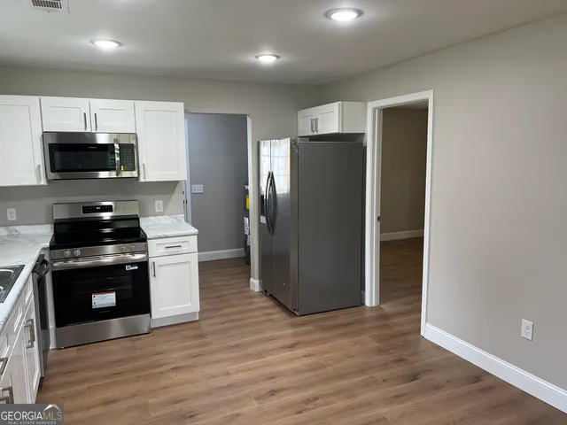 a kitchen with stainless steel appliances a refrigerator stove and microwave